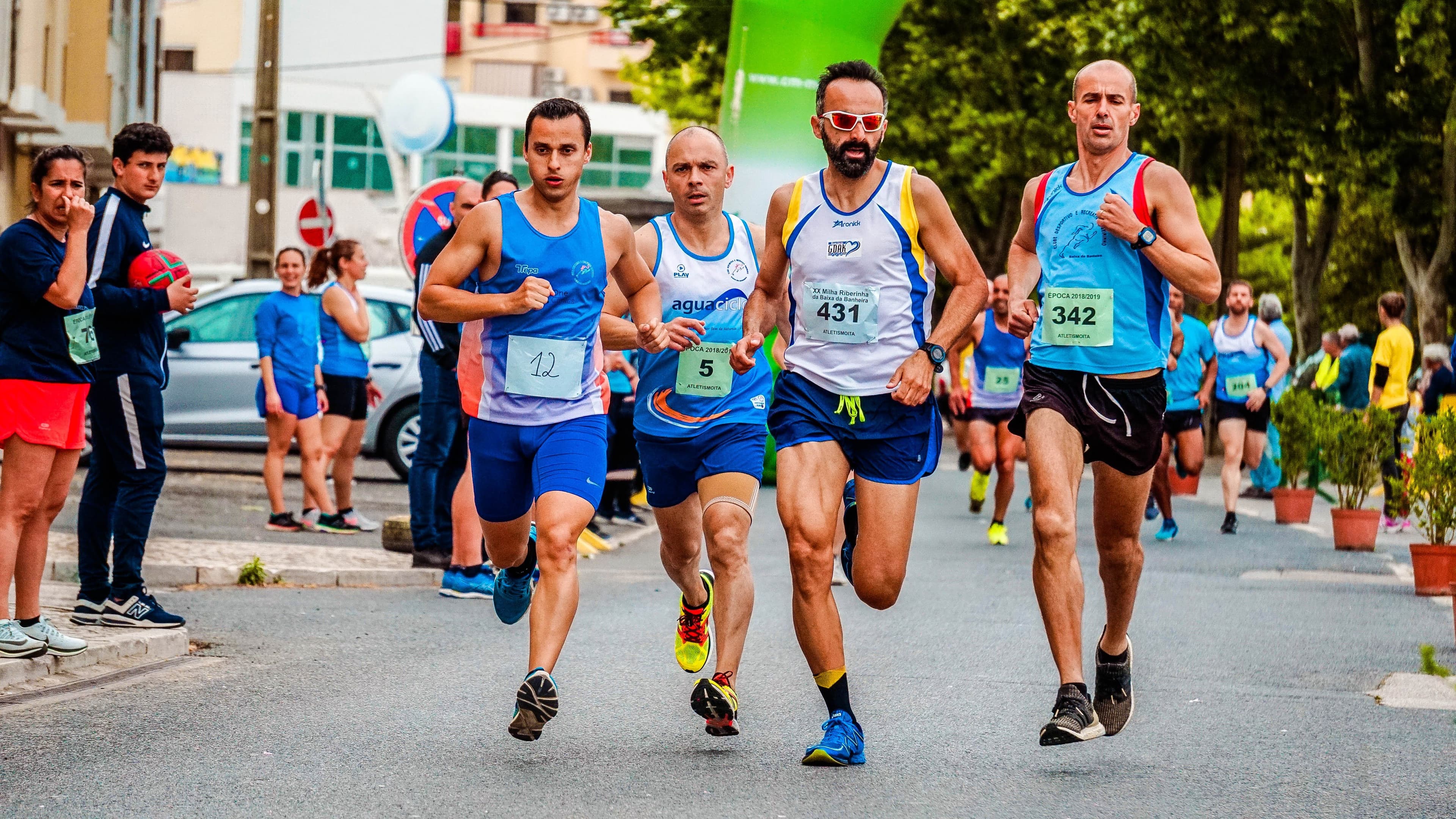 Matched pack of runners racing through a city street
