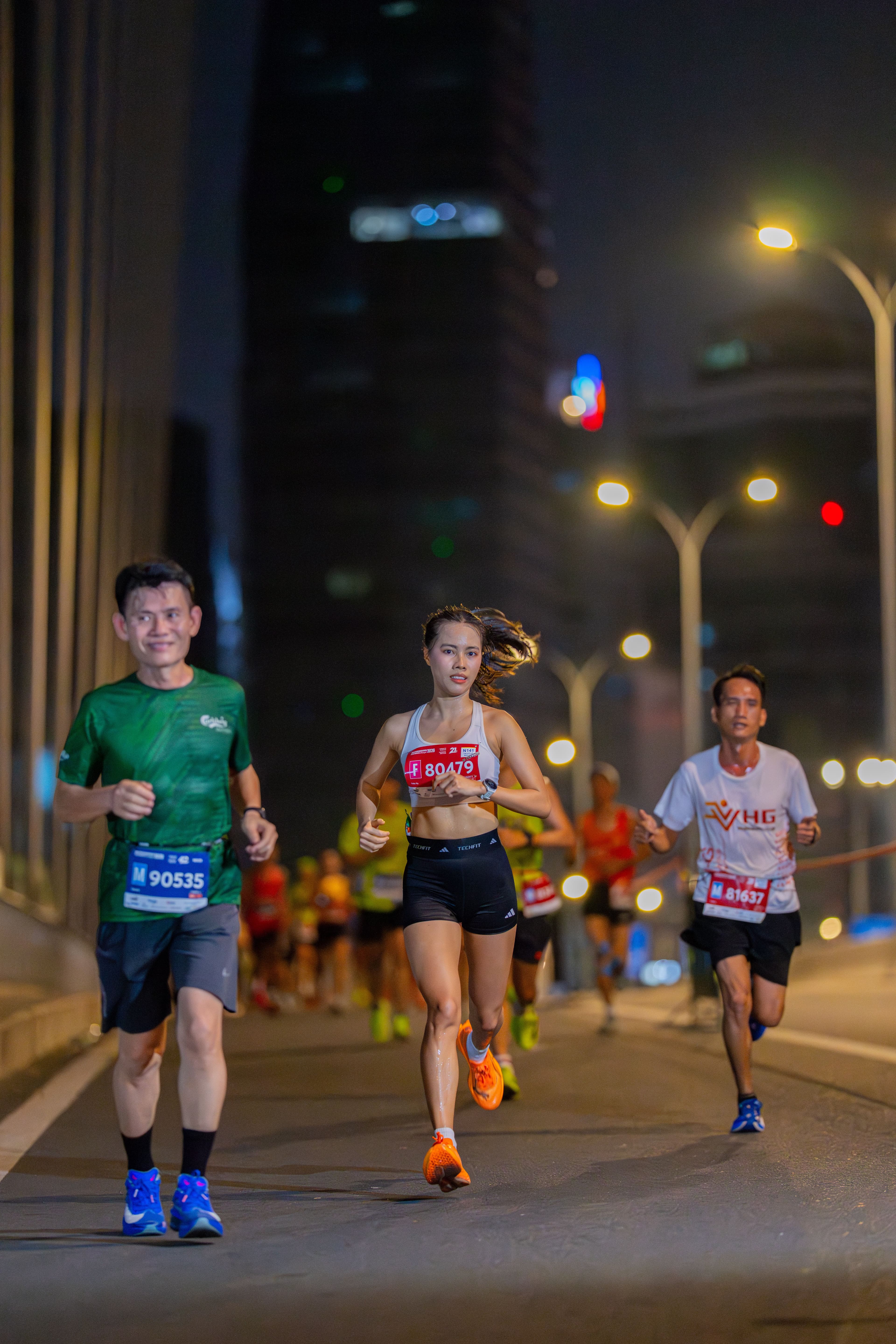 Runners racing at night under city lights
